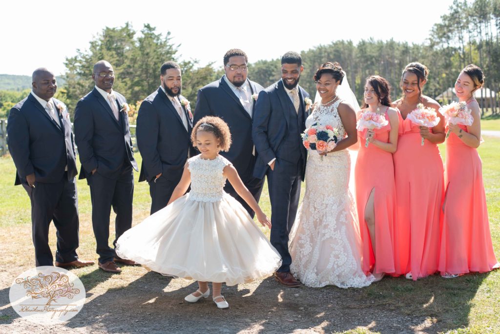 Bridal party with bride and groom in coral dresses and blue suits