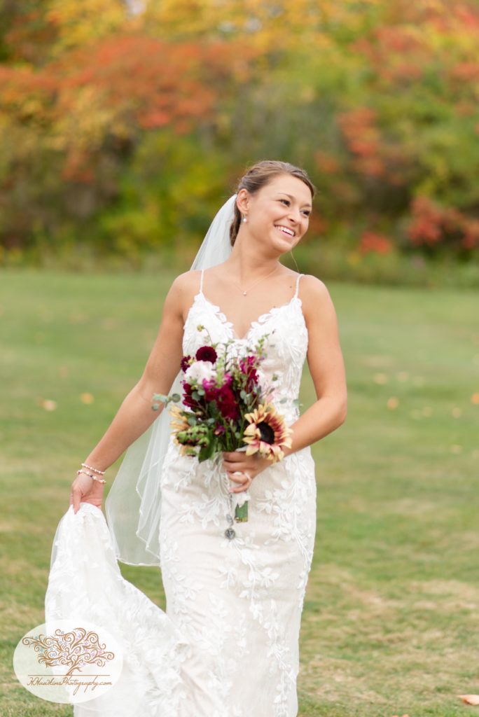 Bride laughs over her shoulder as she walks down a hill at The View at Sunset Pines Executive Golf Course