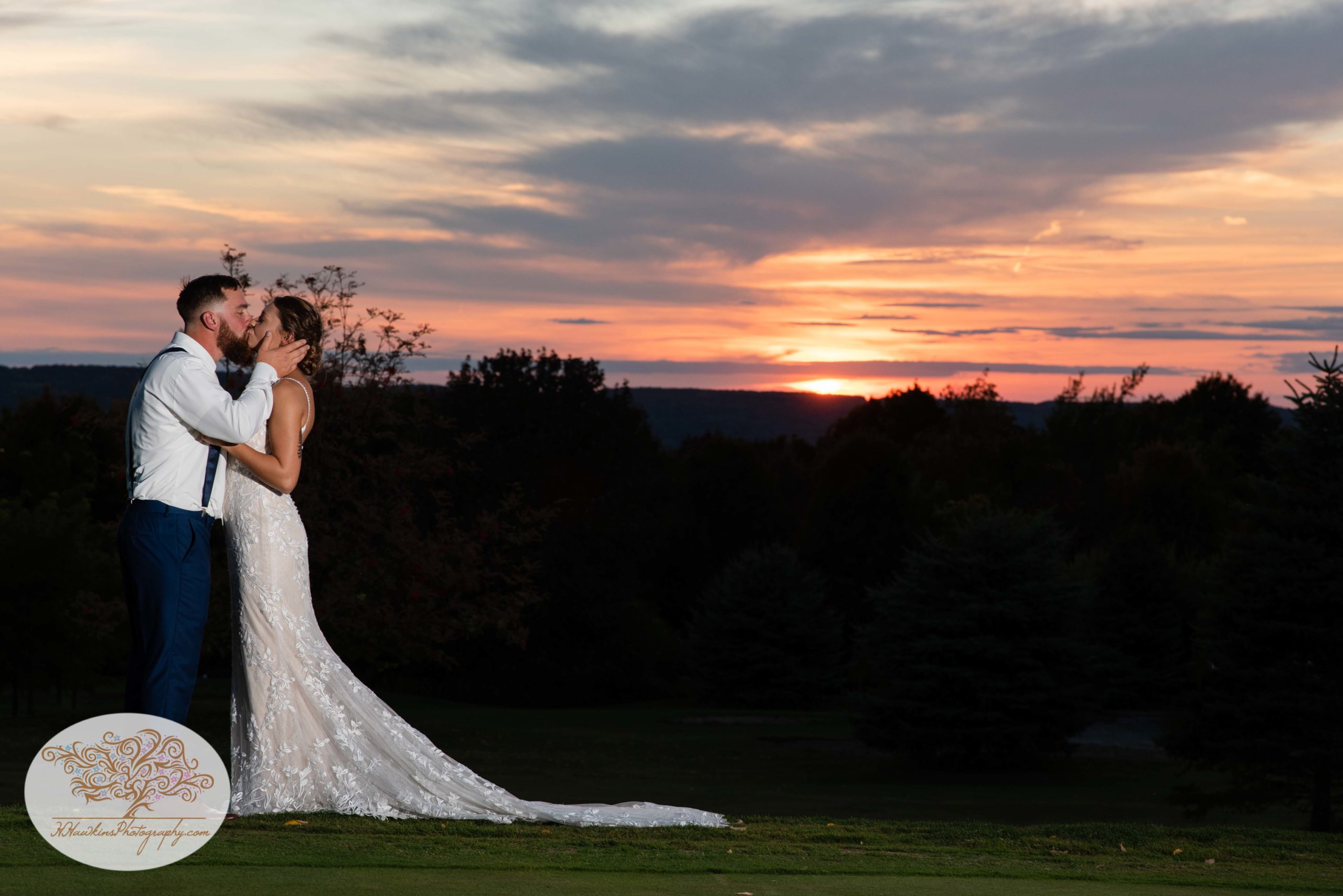 Bride and groom stand in front of a sunset at The View at Sunset Pines in Tully NY