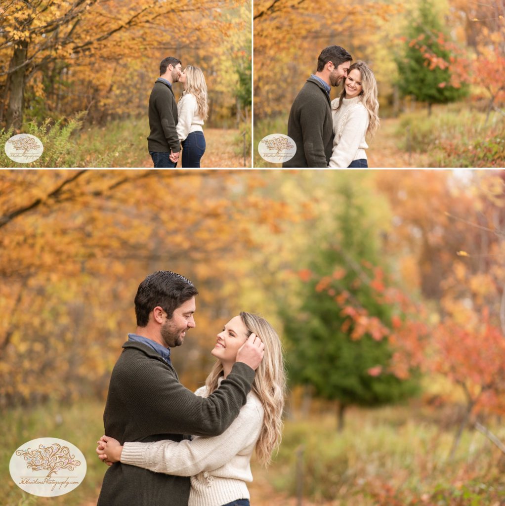 Bride and groom to be stand in the midst of fall foliage for Syracuse engagement pictures at Baltimore Woods Marcellus NY