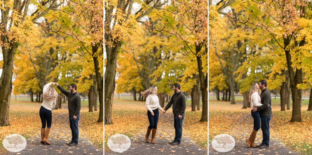 Groom spins bride on a path lined with yellow autumn trees at Marcellus Park for their Syracuse fall engagement pictures