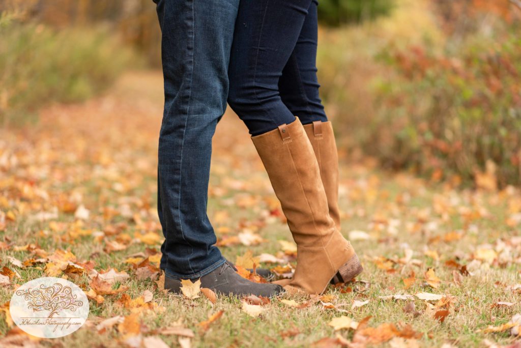 Engaged couple stands with their boots and shoes together during their syracuse fall engagement pictures