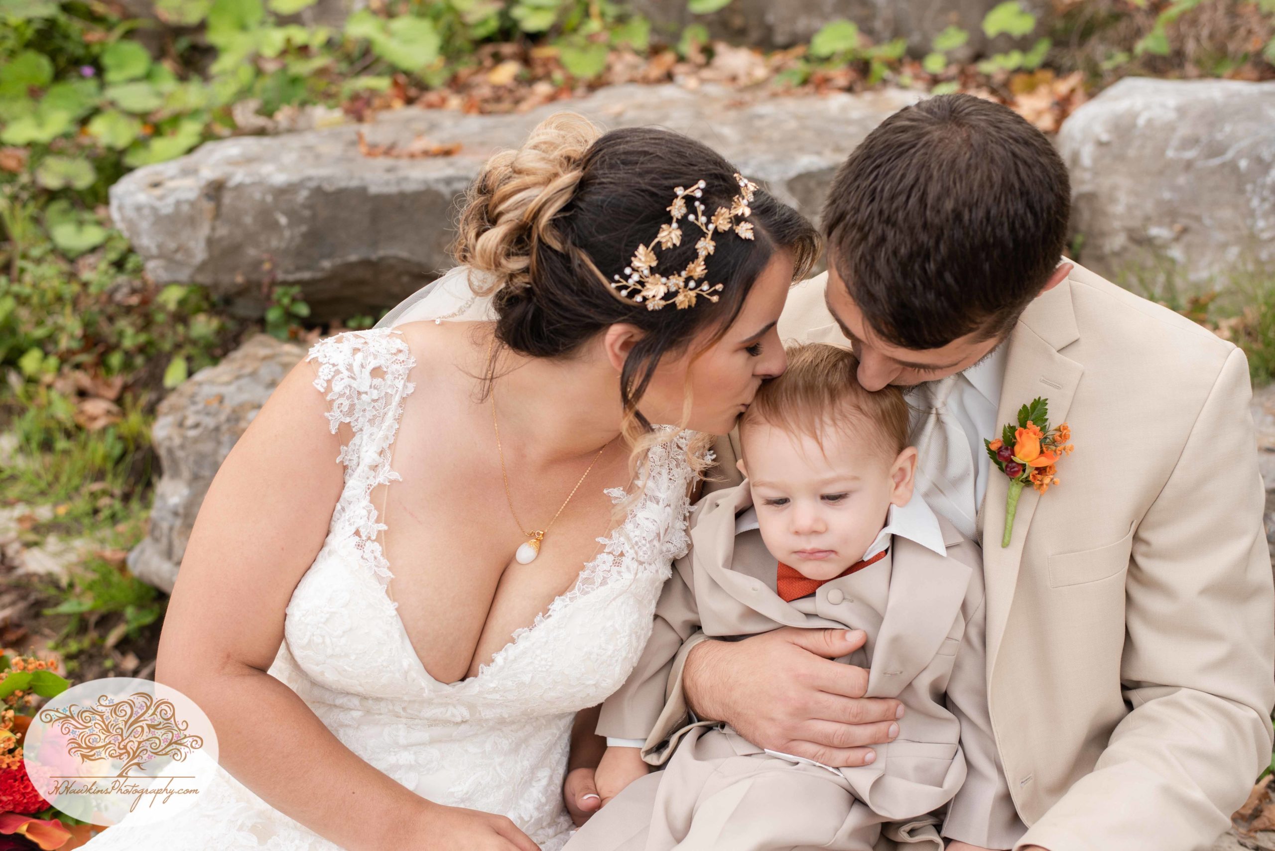 Ring bearer gets a kiss from the bride and groom on their wedding day