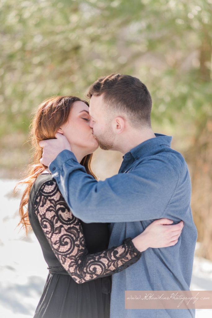 Bride and groom to be kiss during their engagement pictures by Syracuse wedding photographer