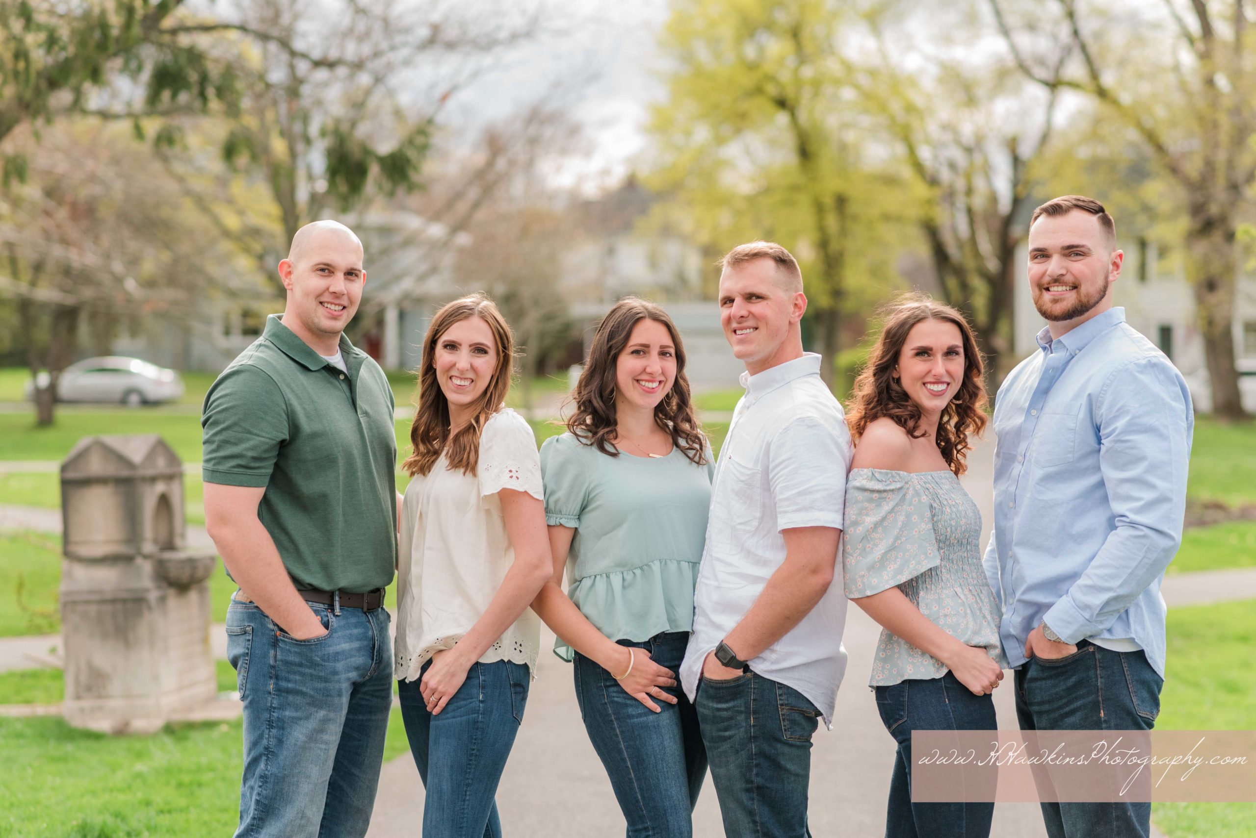 Married siblings stand together during spring family pictures session by Syracuse photographer