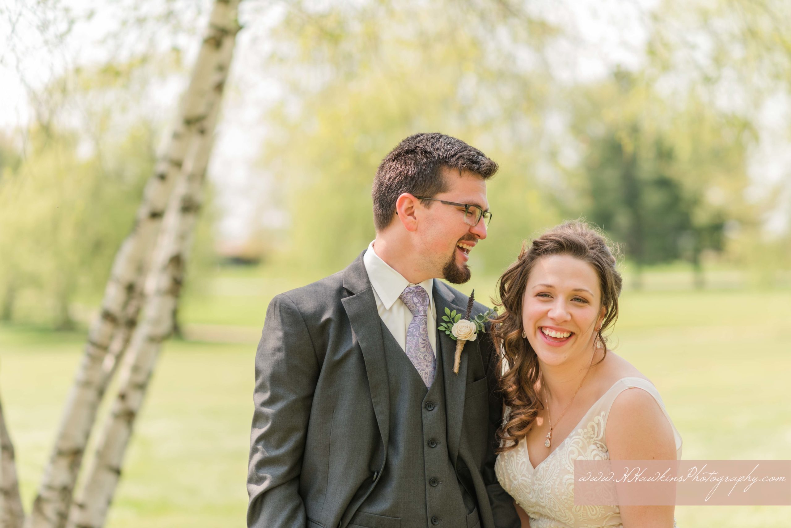 Bride and groom share a laugh together for their golf course wedding pictures