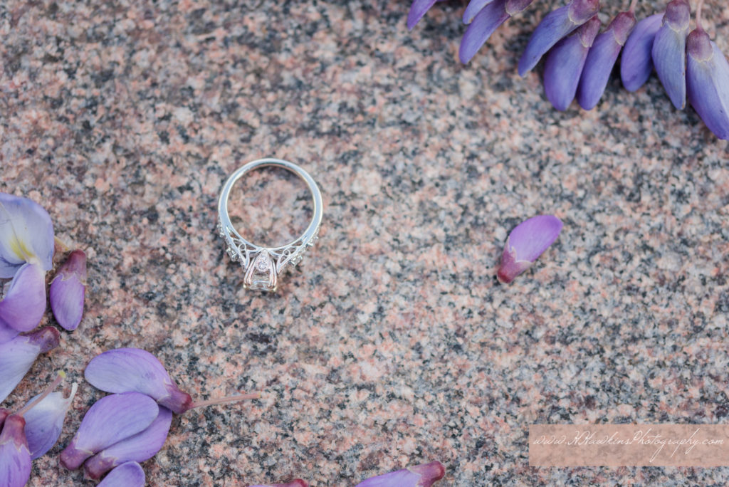 Diamond engagement ring on a lilac blossom during engagement photo session by syracuse wedding photographer