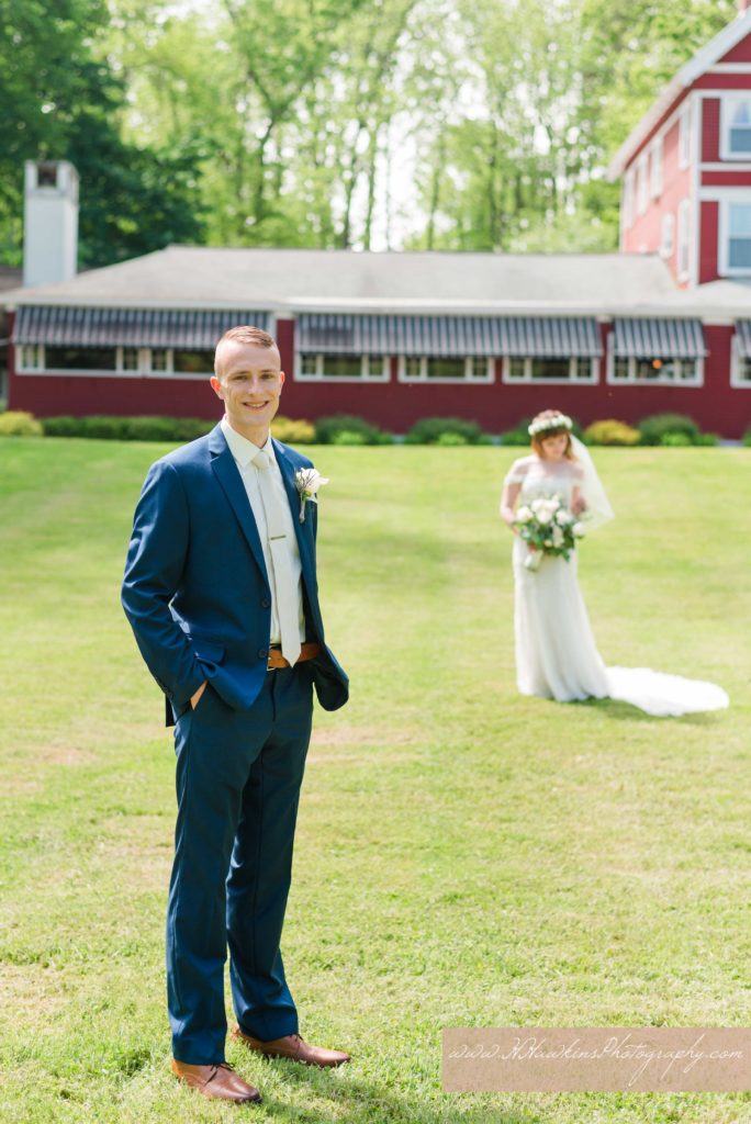 Portrait of groom in focus and bride in the background at the Springside Inn Auburn NY for their wedding