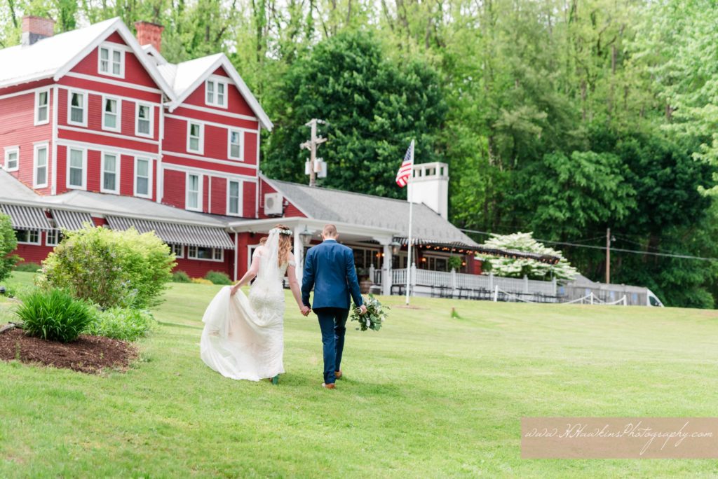 Bride and groom walk hand in hand towards the Springside Inn in Auburn NY on their wedding day