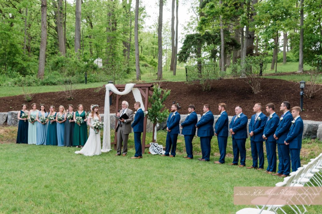Wedding ceremony held at the Springside Inn Auburn NY in the back lawn with bridal party surrounding them