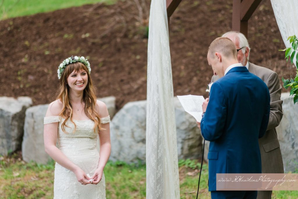 Bride smiles during wedding ceremony on the back lawn of Springside Inn Auburn NY