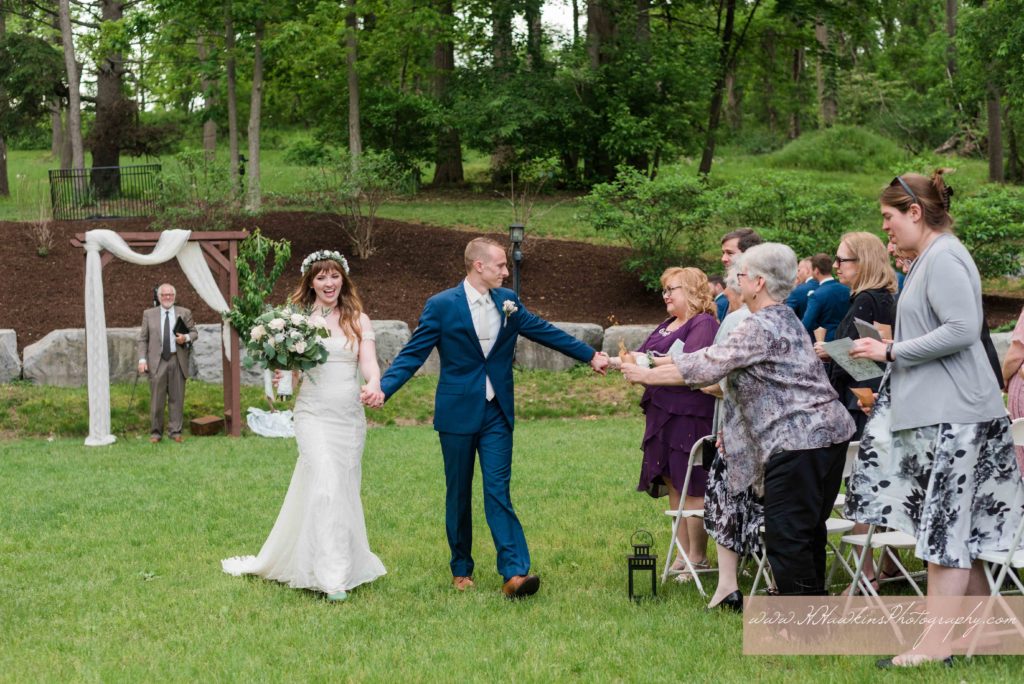 Bride and groom recess down the aisle during their wedding ceremony on the back lawn of Springside Inn Auburn NY