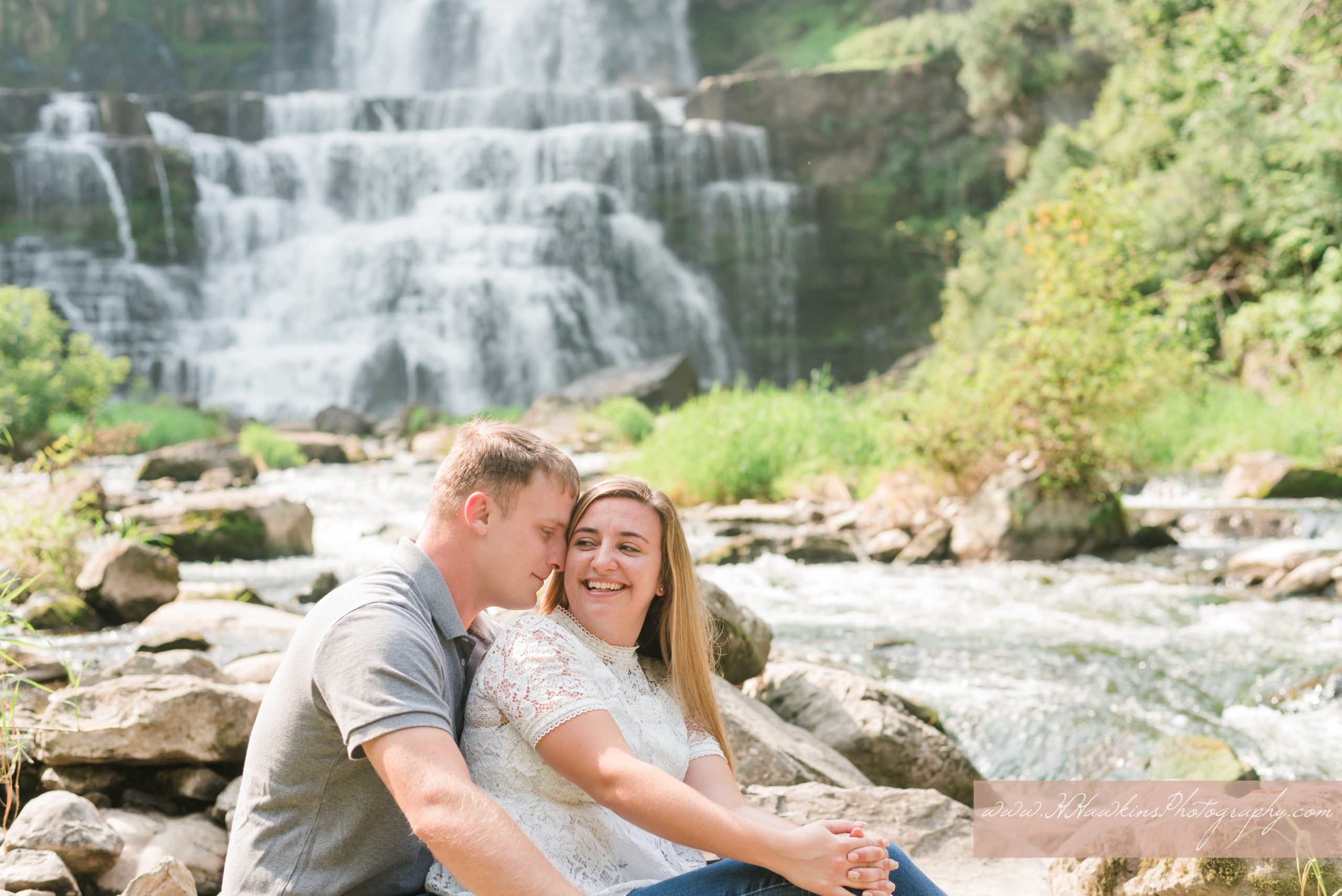 Bride and groom laugh together at the foot of Chittenango Falls during their engagement pictures session by syracuse wedding photographer