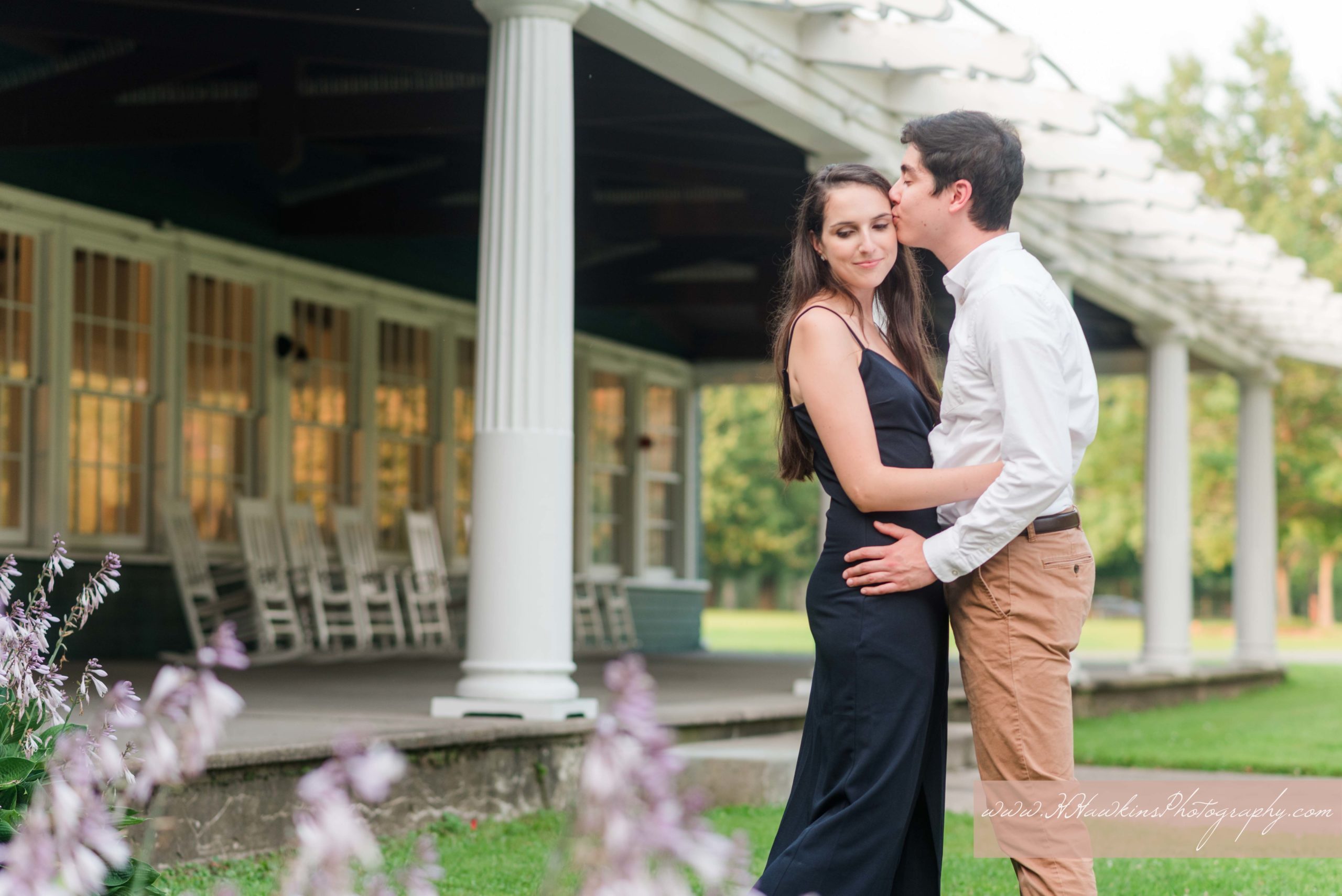 Groom kisses bride on the temple outside of Emerson Park pavilion in Auburn NY for their engagement pictures by Syracuse wedding photographer