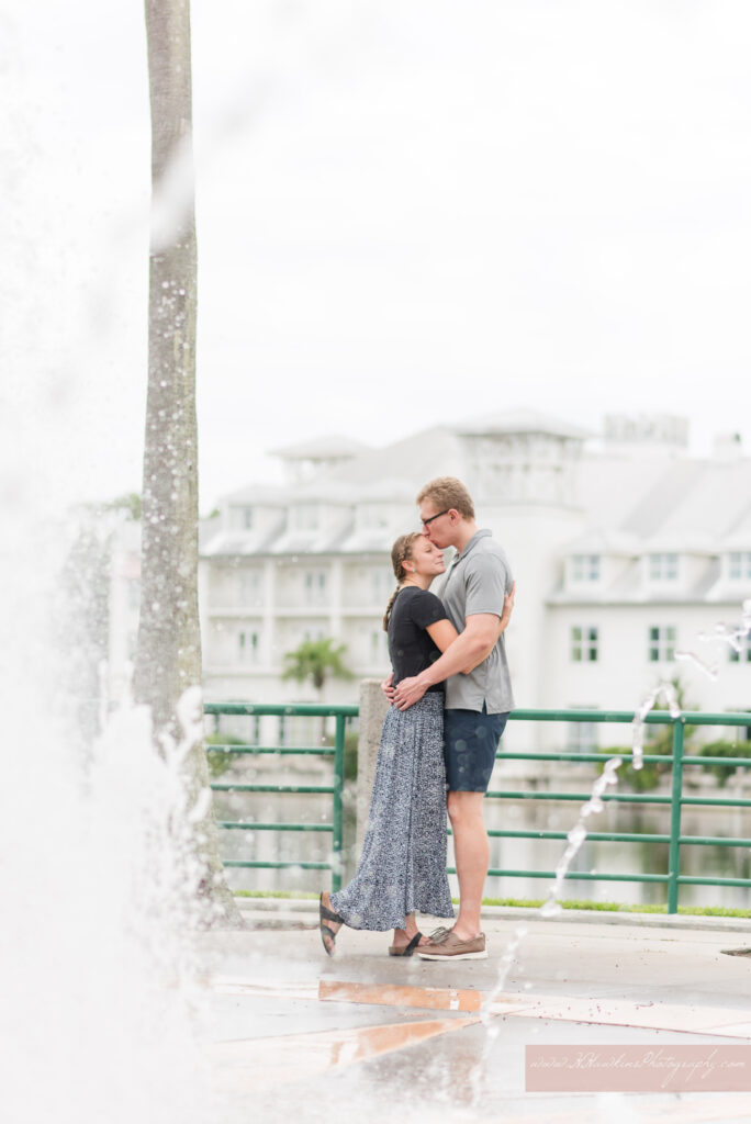 Bride and groom smile at each other in front of Celebration Hotel by splash during their Celebration FL engagement photos
