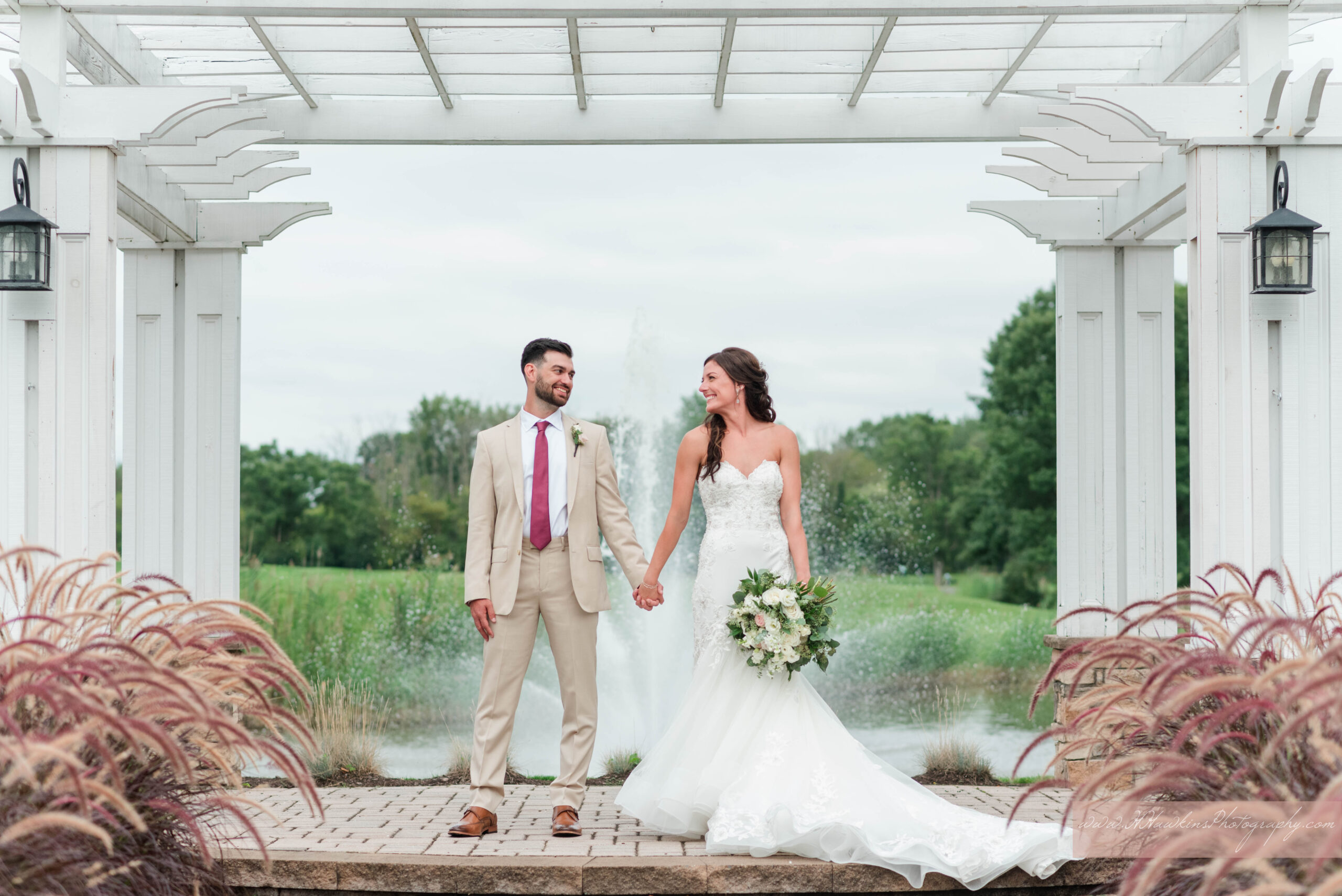 Bride with cathedral length veil and groom during their portrait session at golf course wedding