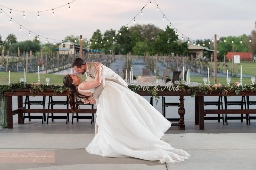 Bride and groom dance under chandelier at Acres of Grace Family Farms wedding venue in Howey in the Hills FL