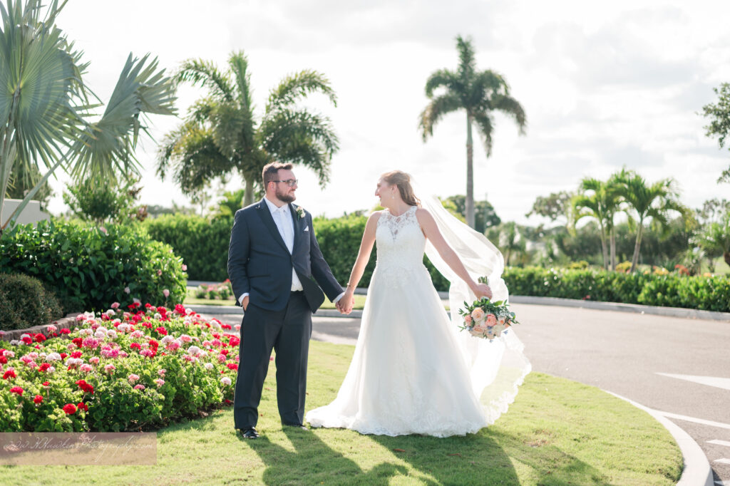 Bride and groom walk together in front of club house of Suntree Country Club in Melbourne FL on their wedding day