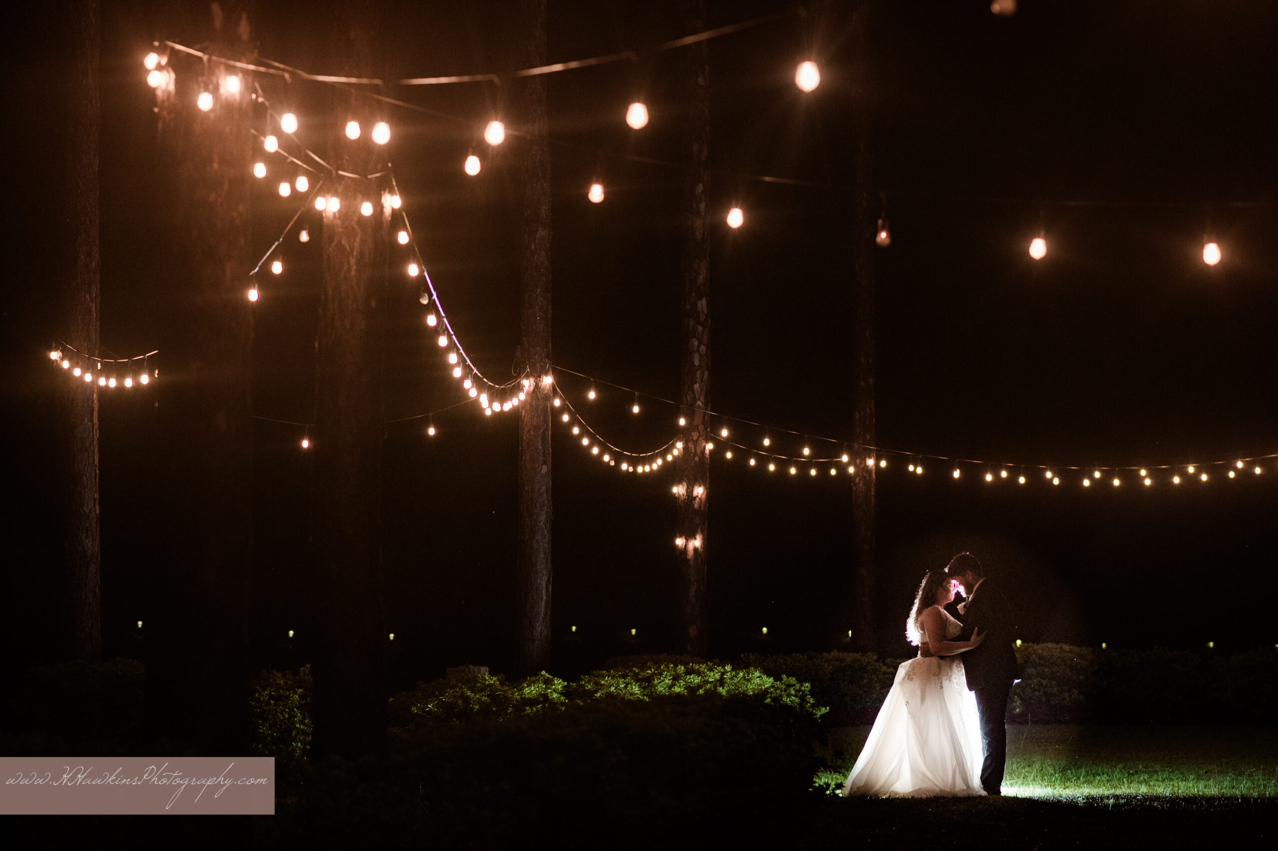 Night time photo of bride and groom under bistro lights at Granville Farms Wedding Venue in DeLand by Orlando photographer