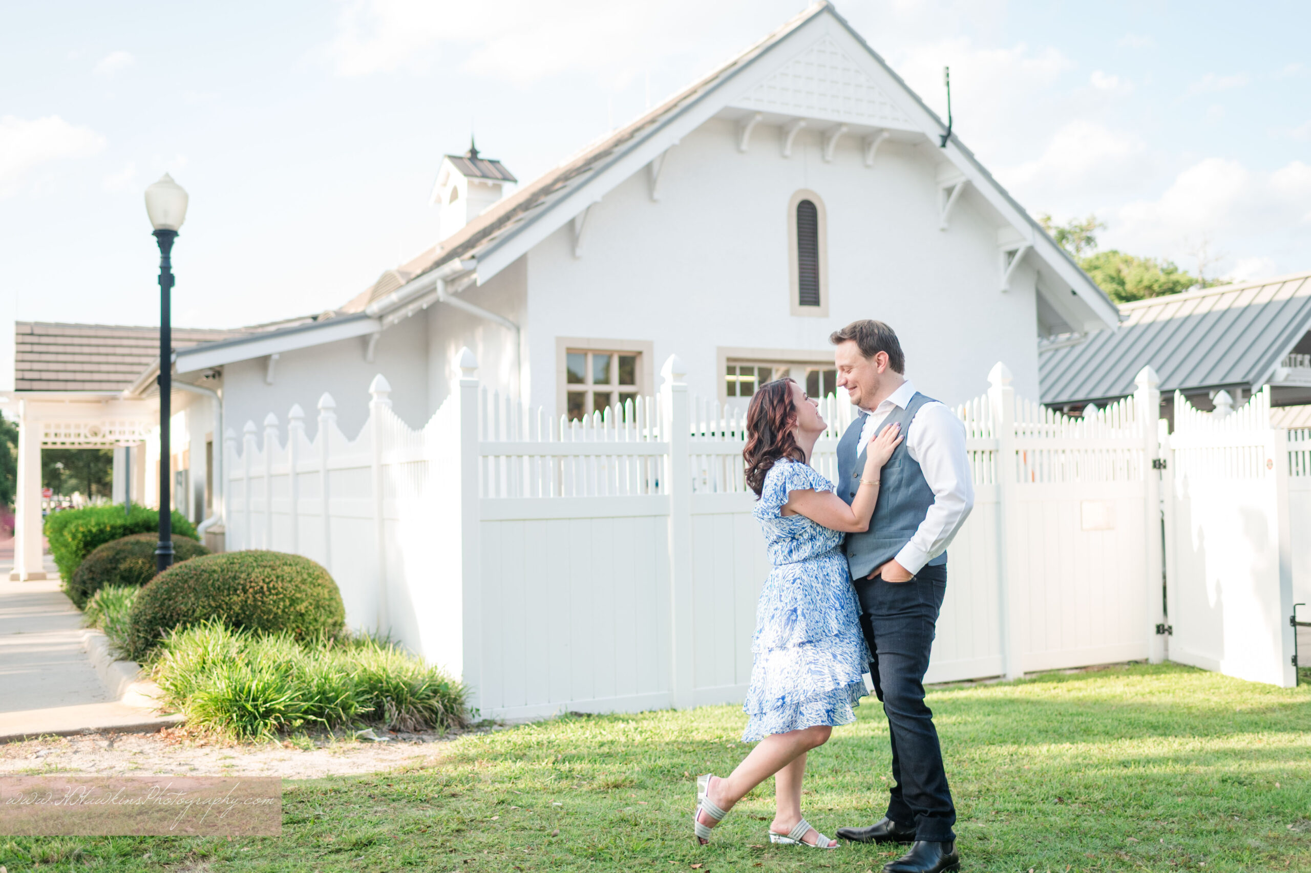 Engagement photos of bride and groom in front of white train station in Winter Park by Florida photographer