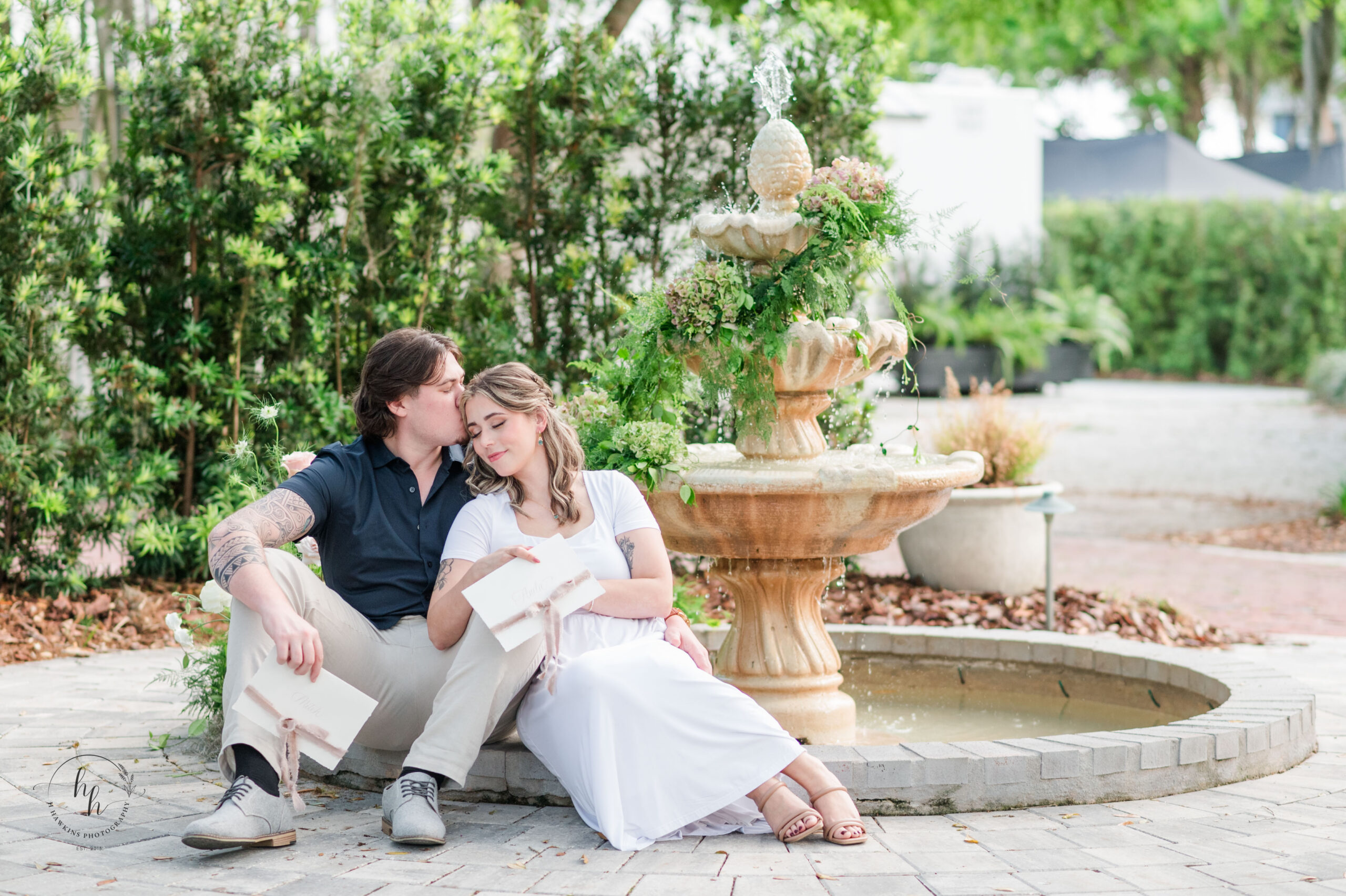 Bride and groom exchange love letters beside the fountain on the East Lawn of Victoria 1883 in New Smyrna Beach